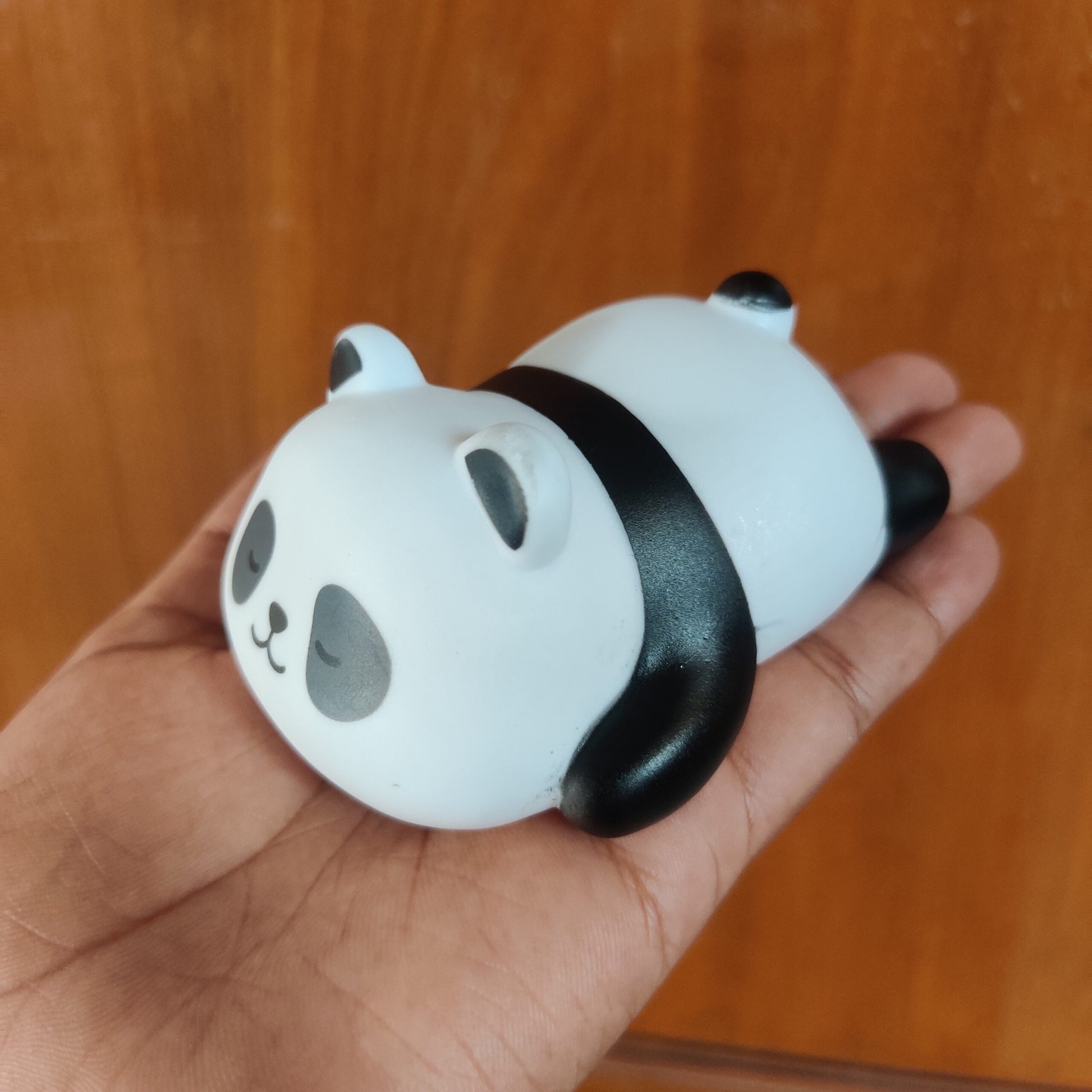 Miniature desktop panda night light in a sleeping pose with soft warm glow