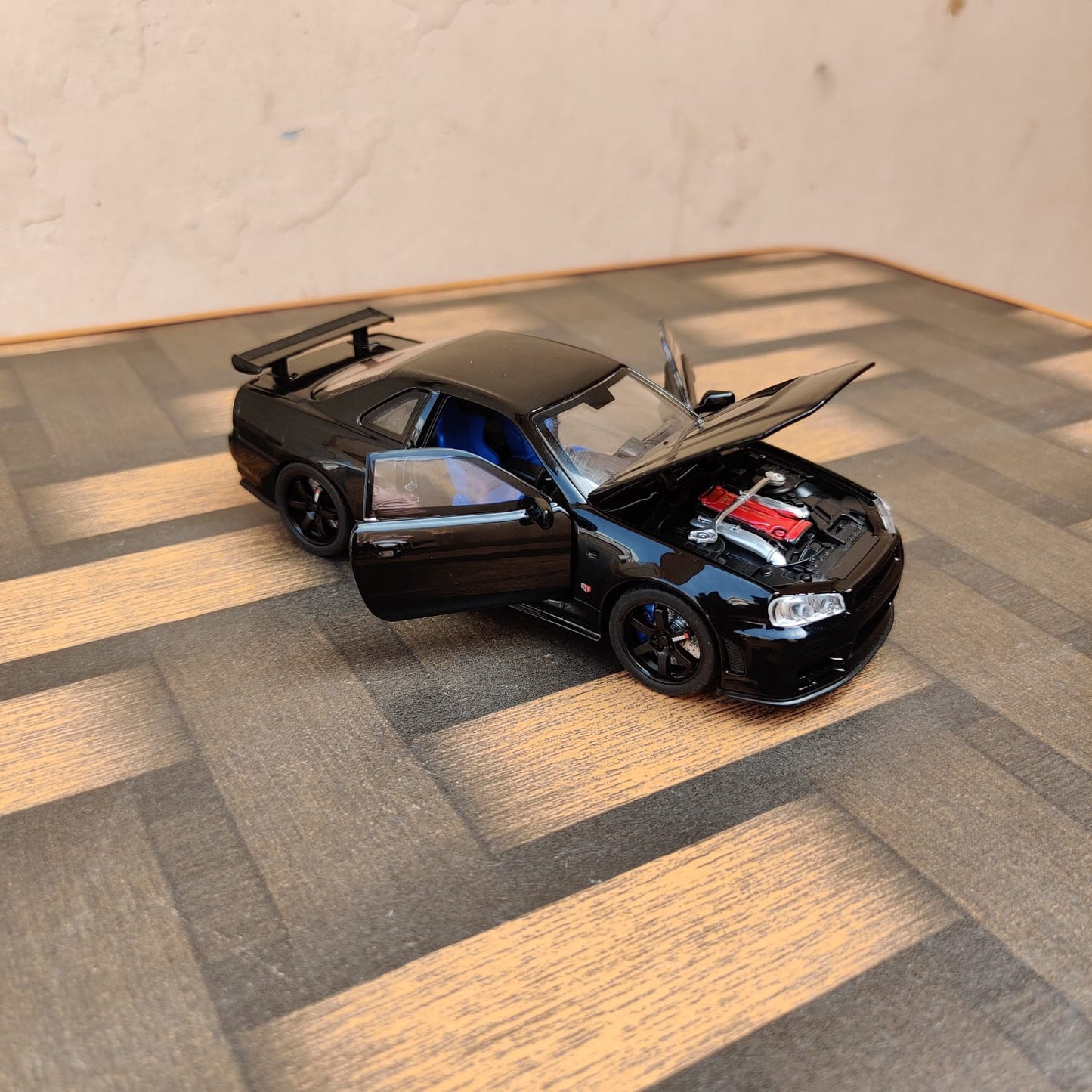 Black die-cast model of a Nissan Skyline GT-R R34 1:32 Scale Openable Doors & Light, Music Toy