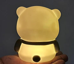 Cute animal-shaped night light held in a hand against a dark background